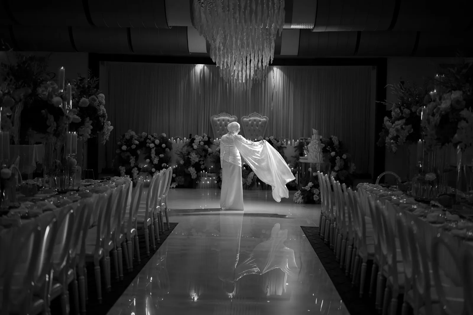 Modern wedding venue with dramatic lighting and rows of elegant white chairs.