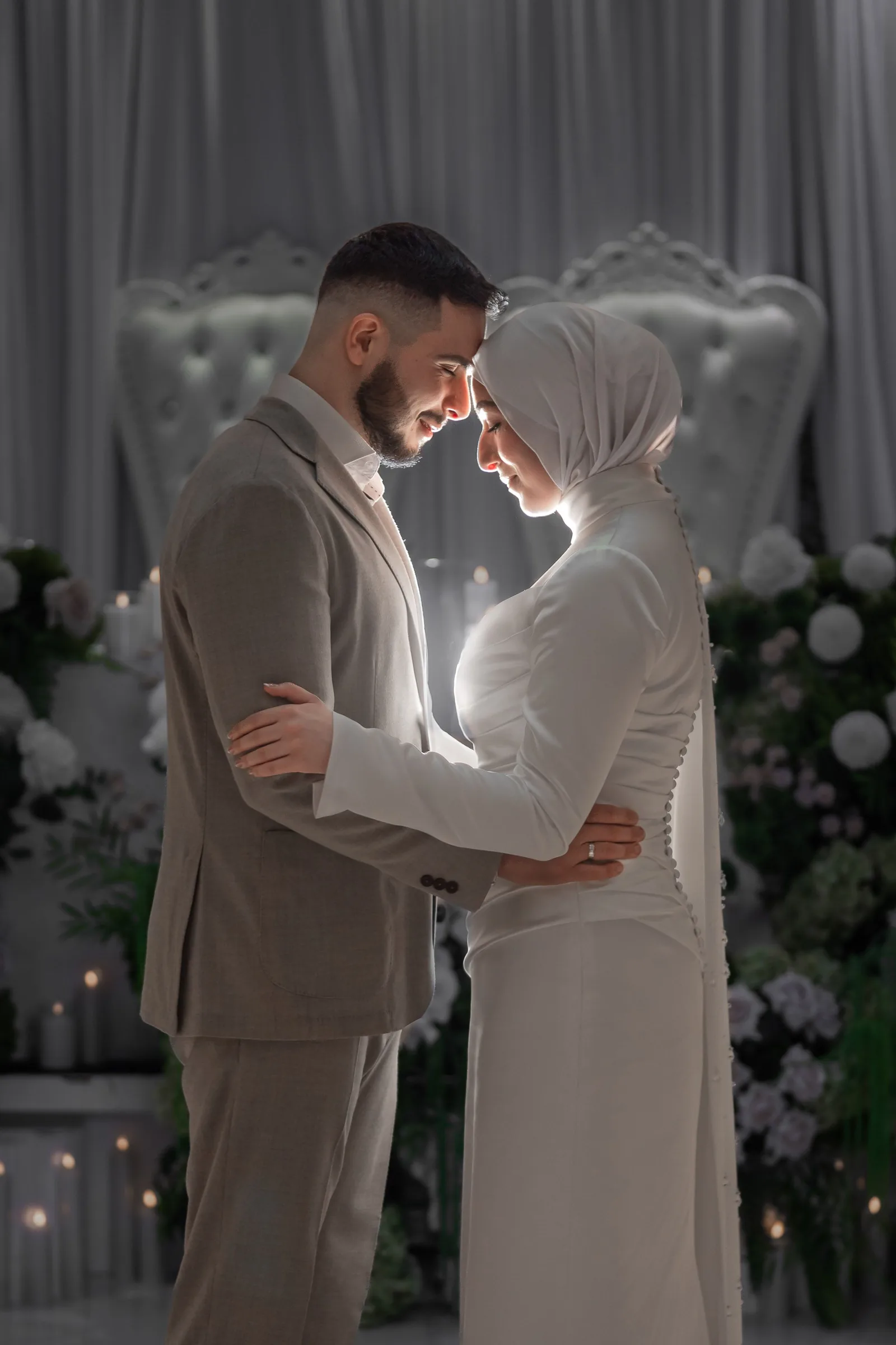 Artistic wedding dance sequence captured in soft lighting with floral backdrop.