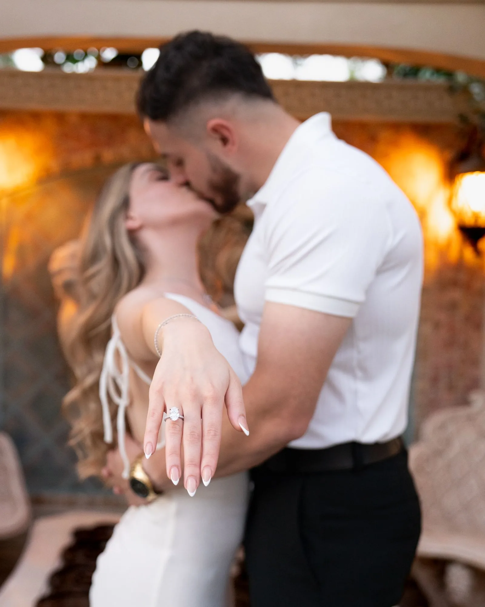 Rita shows her engagement ring while kissing Manoiel in warm evening light