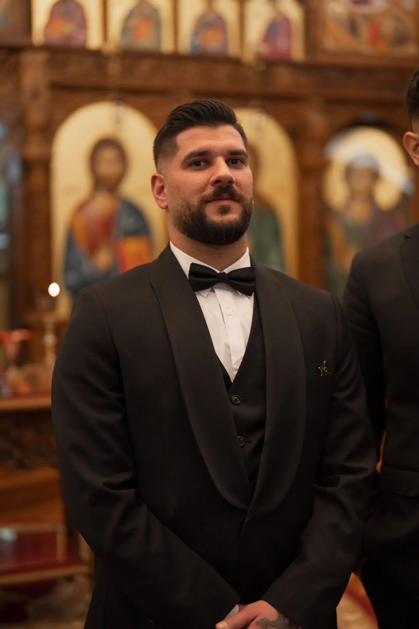Formal wedding portrait inside a church with religious icons and artwork visible in the background.